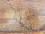 un gros plan d'une table en bois ornée d'un motif de feuilles