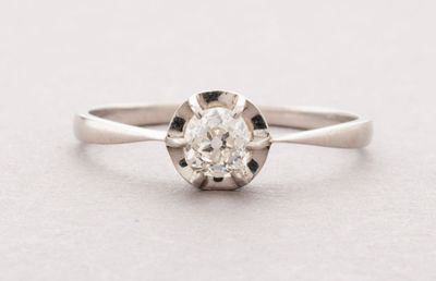gros plan d'une bague en diamant sur une surface blanche
