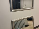 a mirror on the wall next to a radiator in a room