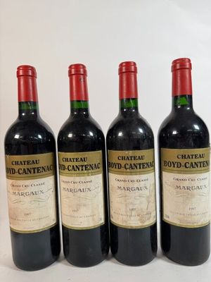 four bottles of wine are lined up on a white surface