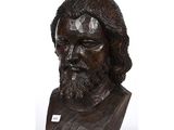 wooden bust of a man with long hair and a beard