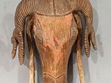 a wooden sculpture of a ram head on the wall