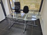 une table en verre avec une chaise noire devant