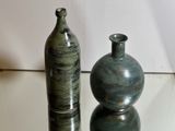 two vases that are sitting on a glass table