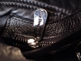 a close up of a zipper on a black leather jacket