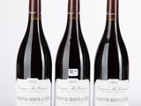 trois bouteilles de vin sont alignées sur une surface blanche