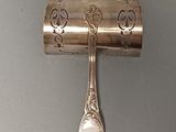 a silver spoon and spoon holder on a wall