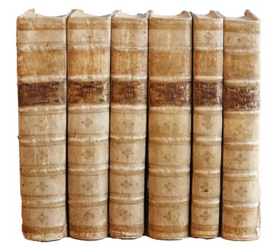 plusieurs vieux livres sont empilés sur une surface blanche