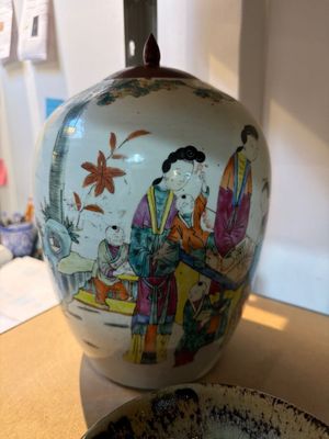 un vase avec un tableau posé sur une table