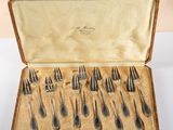 a set of silverware in a wooden case on a table