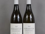 two bottles of wine sitting on top of a table next to each other