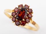 gros plan d'une bague en or avec une pierre rouge