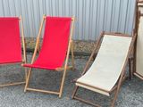 three lawn chairs sitting next to each other on the ground