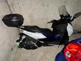 une moto garée à côté d'une voiture bleue