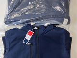 un gros plan d'une veste bleue sur laquelle est accrochée une étiquette rouge et blanche