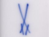 a picture of a blue and white plate with two crossed sticks on it