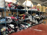 shelves filled with lots of different types of clothing in a warehouse