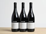 three bottles of wine sitting on top of a wooden table
