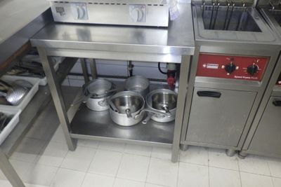 une cuisine avec beaucoup de casseroles et de poêles sur le comptoir