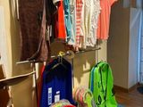 a rack with a variety of clothing on it in a room