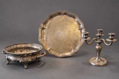 Trois couverts sont posés sur une table, à côté d'un bougeoir.