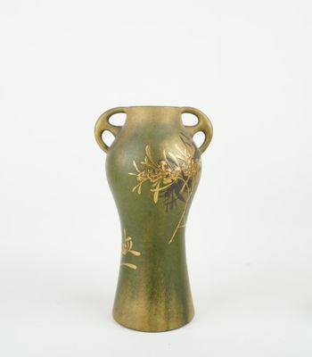 a green vase with a gold decoration on it