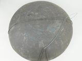 a metal object on a white surface with a wire around it
