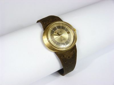 une montre-bracelet en or posée sur une serviette blanche