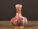 a small vase that is sitting on a wooden table