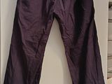 a purple pants hanging on a white wall in a room