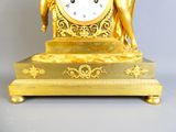 une horloge en or sur laquelle sont représentés un homme et une femme