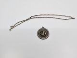 a silver coin with the word us on it and a chain around it