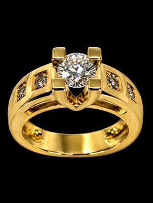 a close up of a gold ring with a diamond in the center