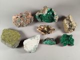 a close up of a group of different colored rocks on a white surface