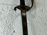 a sword hanging on a wall with a tag on it