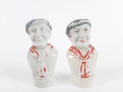 deux figurines en céramique représentant un homme et une femme sur fond blanc