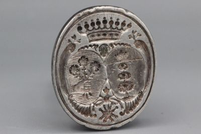 une vieille pièce d'argent sur laquelle est gravée une couronne, posée sur une table