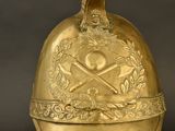 a gold bell with a bird on top of it