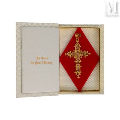 une croix rouge et or dans un coffret orné d'un ruban rouge