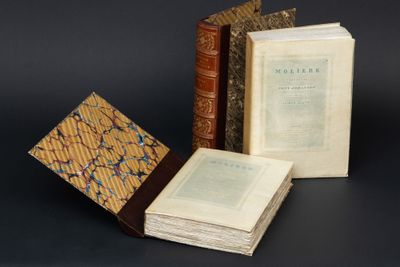 trois livres sont empilés sur une table