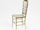 a gold metal chair with a cushion on top of it