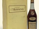 the bottle of hennessy is next to a box of wine