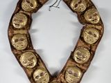 a close up of a gold necklace with skulls on it