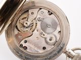 a close up of a pocket watch on a white surface