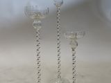 three clear glass wine glasses sitting on top of a white table