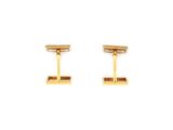 a pair of gold cufflinks on a white background