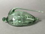 a green glass object that is sitting on a table