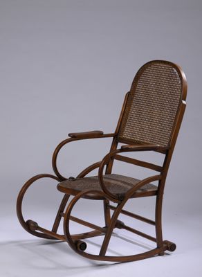 un vieux fauteuil à bascule avec une assise en osier sur fond blanc