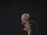 a close up of a violin sitting on top of a wooden table