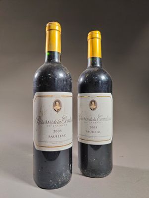 deux bouteilles de vin posées sur une table l'une à côté de l'autre
